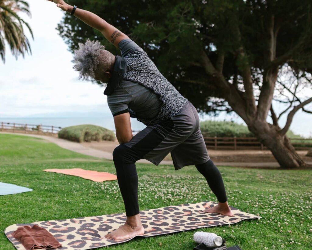 Man doing balance training on mat in park.