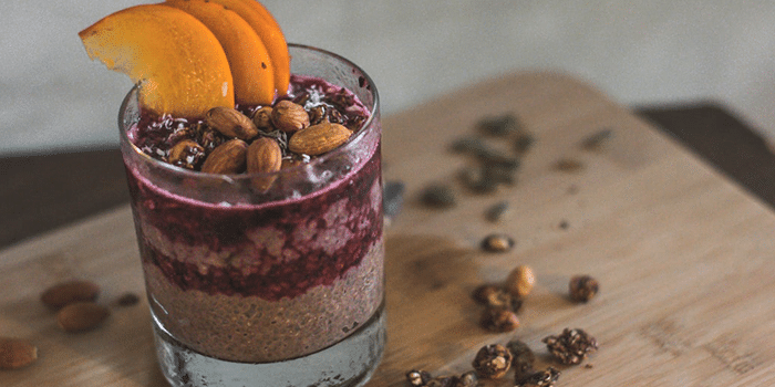 cup with chocolate chia pudding on a wood cutting board